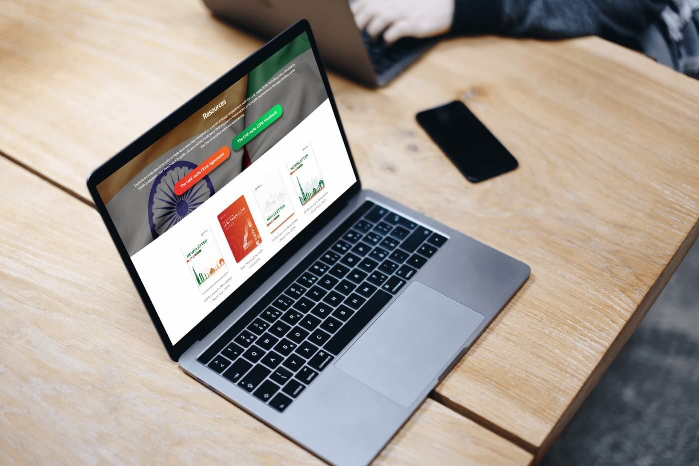 Laptop on a wooden desk showing the website homepage