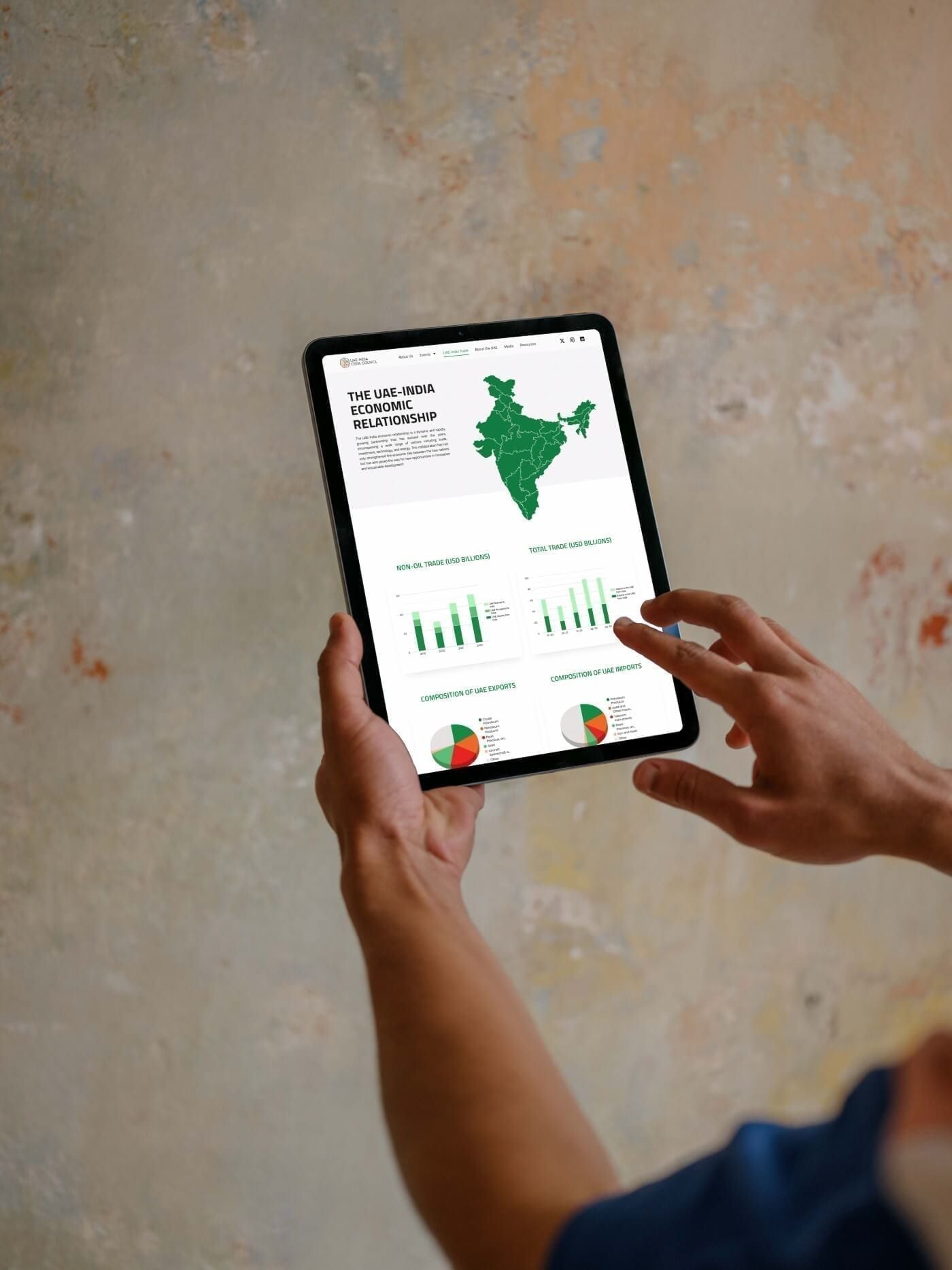 Tablet held in two hands showing a page with a map of India